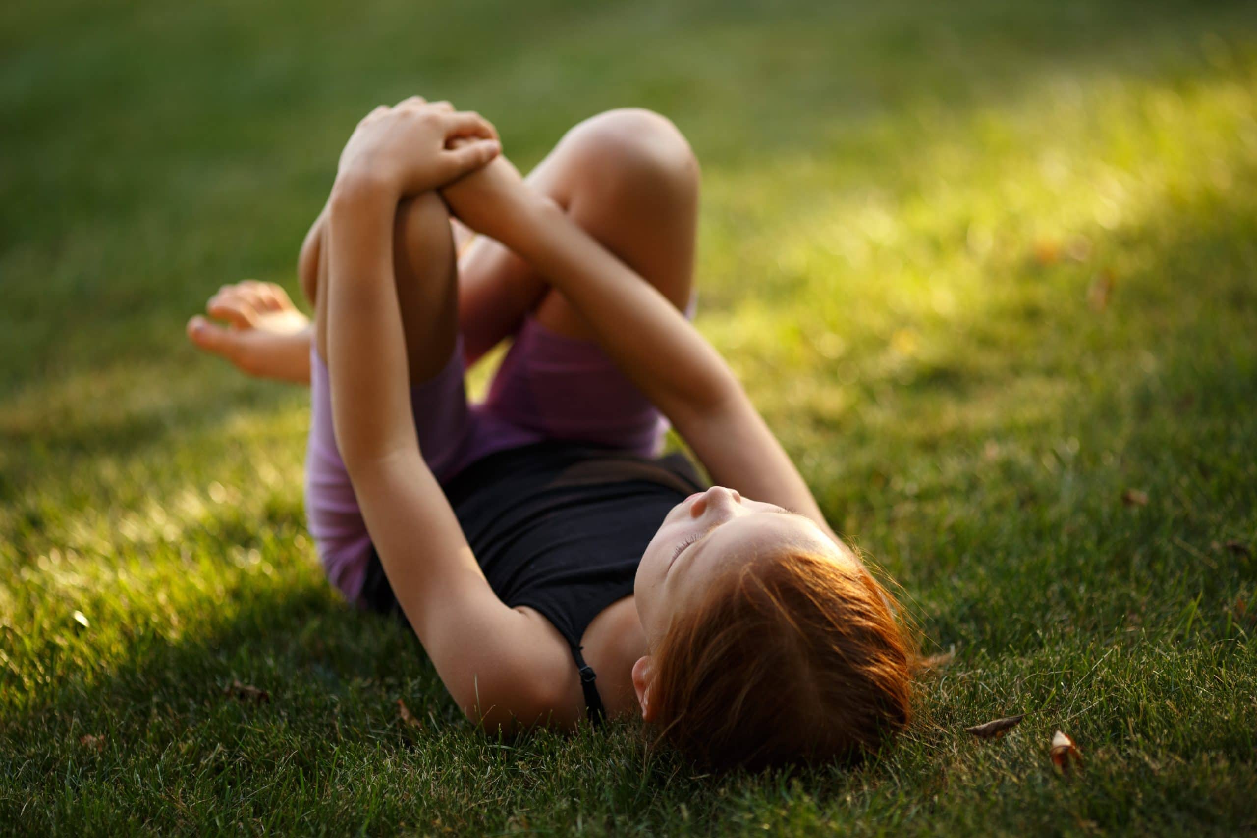 Young girl lying on green lawn